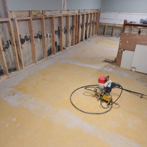 Basement Wall With Exposed Wooden Studs And Concrete Foundation Showing Signs Of Water Damage, With Foundation Repair